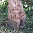 Sculpture de petites maisons dans un vieux montant de portillon