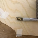 pièce découpée grâce à la scie à arbalète, déposée sur lame de cutter pour voir la taille