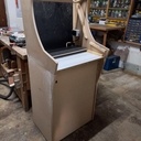 Le corps est réalisé en 2 parties: Le haut (Bar top) contenant l'écran et tous l'ensemble électronique. Le bas servant de pied pour rangement des notices, manettes de jeux additionnelles, câbles, ...