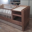 Le lit en mode petit bébé avec le sommier surélevé, table à langer et barreaux.