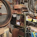 En face de l'établi, à gauche : étagère à outils métallique, scies montées