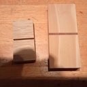 un domino taille normal, le premier domino encore trop petit, le domino final en sapin avec une insersion en bois exotique