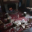 Des bouts de bois vert, des billots, des haches et des couteaux de sculpture au coin du feu ouvert.