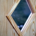 Porte de service en mélèz et ca petite vitre en losange.