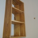 le meuble est fixé au mur par deux grosses visses chevillées, le tout s'insère dans le chant des parois verticales au moyen d'une fraise en "trou de serrure"