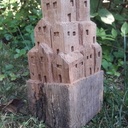 Sculpture de petites maisons dans un vieux montant de portillon