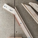 Découpe des motifs en placage de tinéo pour le frisage du panneau du fond. Gabarit fixé sur la scie à format avec un tasseau à 30 degrés, et un autre à 120 degrés.