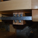 deux rails en aluminium parfaitement parallèles, qui coulissent entre 3+2 roulements, de chaque côté du bloc de bois