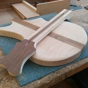 A ce stade, j'ai usiné une rainure qui recevra une tige de réglage (elle permet de régler la courbure du manche lié à la tension des cordes) le manche à été dégrossie et j'y ai collé un placage de noyer sur la tête