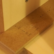 Gabarit de perçage posé en bas de meuble