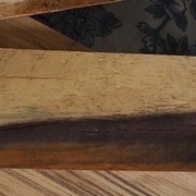 Une planche en bois avec des couleurs très marquées : de l'ivoire, un brun qui tire sur le violet et un brun orangé