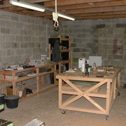 Un coin de l'atelier, avec un établit et une table de travail.