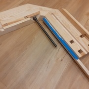 Sous la presse : on voit la queue, la vis et ses écrous et contre-écrou et les rainures