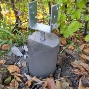 Un plot béton avec le support de pied pris dedans, une fois le coffrage en PVC retiré.