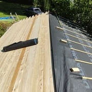 Après le voligeage, mise en place d'un pare-pluie du bas vers le haut. Un pare-pluie est cependant mis à cheval sur les deux pans au faitage