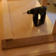 Gabarit de perçage posé en milieu de meuble avec un cale d'alignement