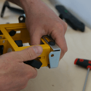 Dévissage du bouton de réglage en hauteur situé à l’extérieur du support DeWALT DE7024.