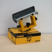 Support de pièce DeWALT DE7024 avec sa butée de longueur d’origine, posé sur son emballage.