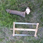 Découpe de la bûche sur le bord de la brouette en tenant d'une main et en sciant de l'autre sans forcer