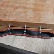 La charnière toute simple, avec un ruban collé-cloué après pré-perçages dans l'axe des séparateurs de plateaux