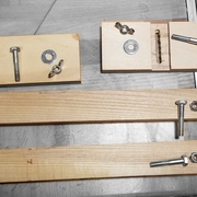 les traverses horizontales avec leurs ouvertures en crochet, et les ajustements de hauteur et de niveau de la desserte.