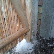 On aperçoit sous le montant, le dessus du coin en acacia qui m'a permis de remettre le vieux poteau béton d'aplomb.