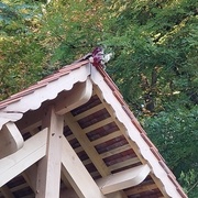 Les planches de rives reprennent sur leur partie basse les motifs retrouvés sur les autres bâtiments du lieu, datant pour certains du 18e siècle. Le bouquet pour fêter la fin de la charpente est présent !