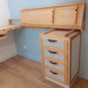 Le plan du bureau est relevé et verrouillé par une grenouillère. On voit au passage les barres de blocage latéral