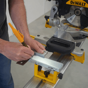 Repérage précis du trou de fixation sur le support DeWALT DE7024 à l’aide d’une équerre et d’un marqueur.