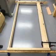 Montant de la porte positionné dans le bâti pour marquer l'emplacement des paumelles sur le montant du bâti