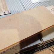 un bout de MDF pressé dessus avec du double face, pour pouvoir appuyer lors du fraisage, tenir le tout une fois coupé, et éviter les éclats