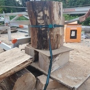 La buche est sanglée à la scierie. Un coupe de propreté est réalisée d'un côté puis nous ajoutons une plache dessous avant de retourner.