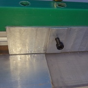 Vis de fixation de la défonceuse sur l'équerre qui traverse la pièce verte