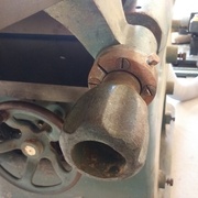 La poignée de réglage de la table de sortie est démontée pour nettoyage. Les vis sont changées.