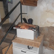 un meuble avec le dessus occupé par les affaires de BBQ, des bottes d'enfant et le grand tiroir plein de chaussures