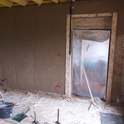 Dépose de la porte, pré-ébrasements en OSB pour avoir de quoi visser les ébrasements. Enduits terre en cours..