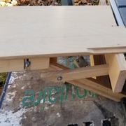 La desserte fixée à la scie de chantier. On voit les écrous papillon qui servent à mettre de niveau le plateau.