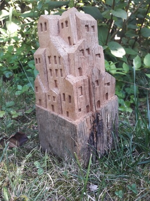 Sculpture de petites maisons dans un vieux montant de portillon