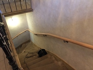 Pose d'une main courante sur un vieil escalier.