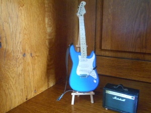 Une guitare miniature et son ampli
