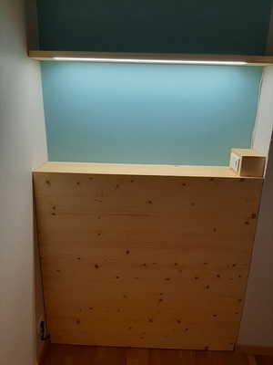 Une tête de lit et son étagère lumineuse