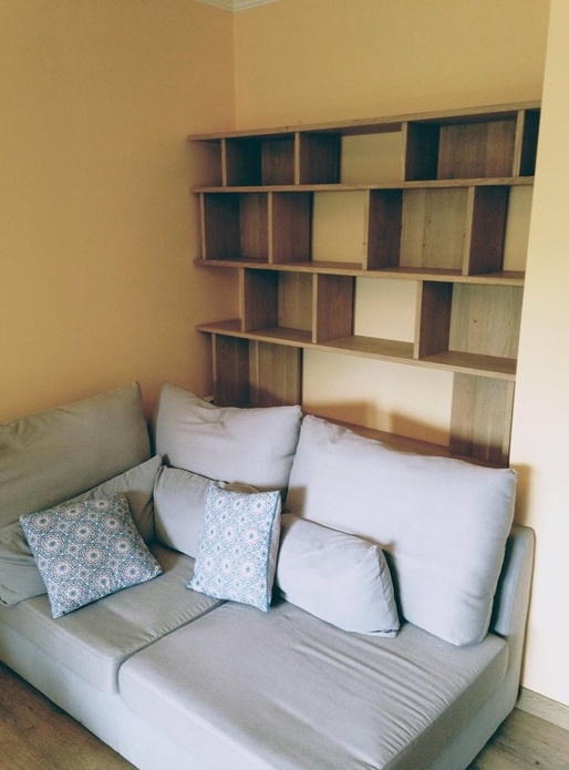 Une bibliothèque derrière un canapé