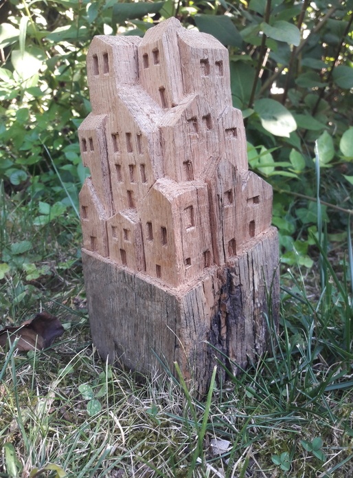 Sculpture de petites maisons dans un vieux montant de portillon