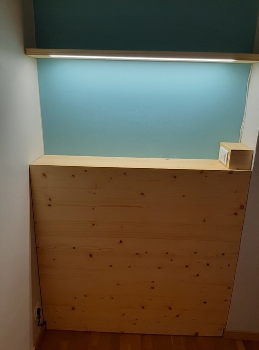 Une tête de lit et son étagère lumineuse