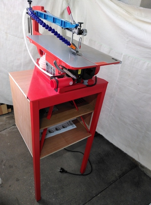 Un coffre de rangement dans le trépied de la scie Hegner