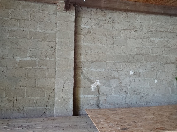 Les fissures semblent traverser le mur, au niveau d'un pilier probablement pas d'origine.