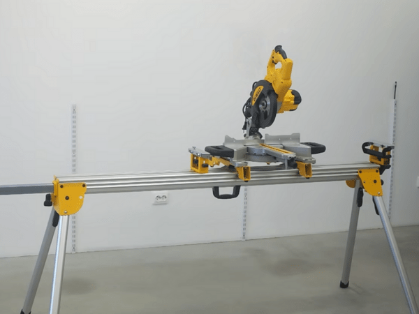 Scie à onglet DeWALT montée sur un piétement DE7023-XJ avec supports de pièce installés de chaque côté.