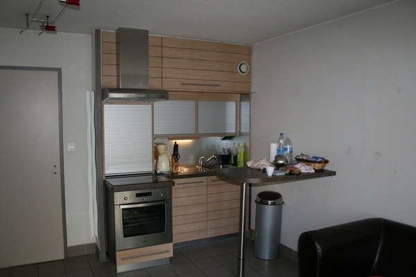 Après l'agence de voyage, une cuisine atypique avec une partie sous un escalier