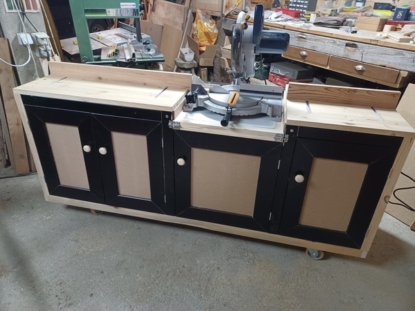 Le meuble avec la scie radiale en service