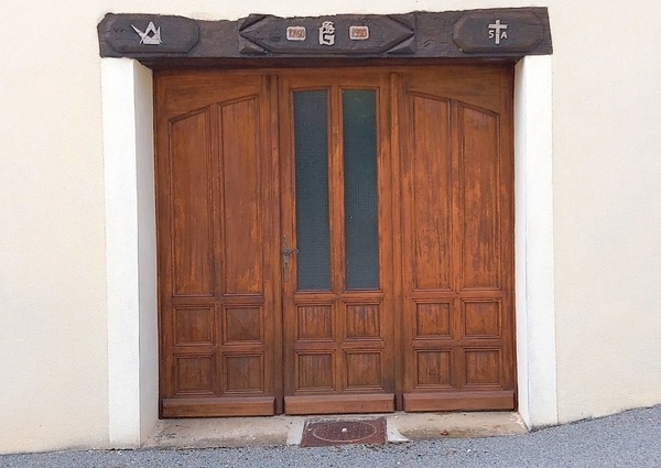 Linteau sculpté et porte de garage traditionnelle